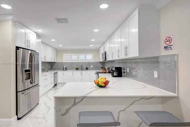 a kitchen with a sink a counter space stainless steel appliances and cabinets