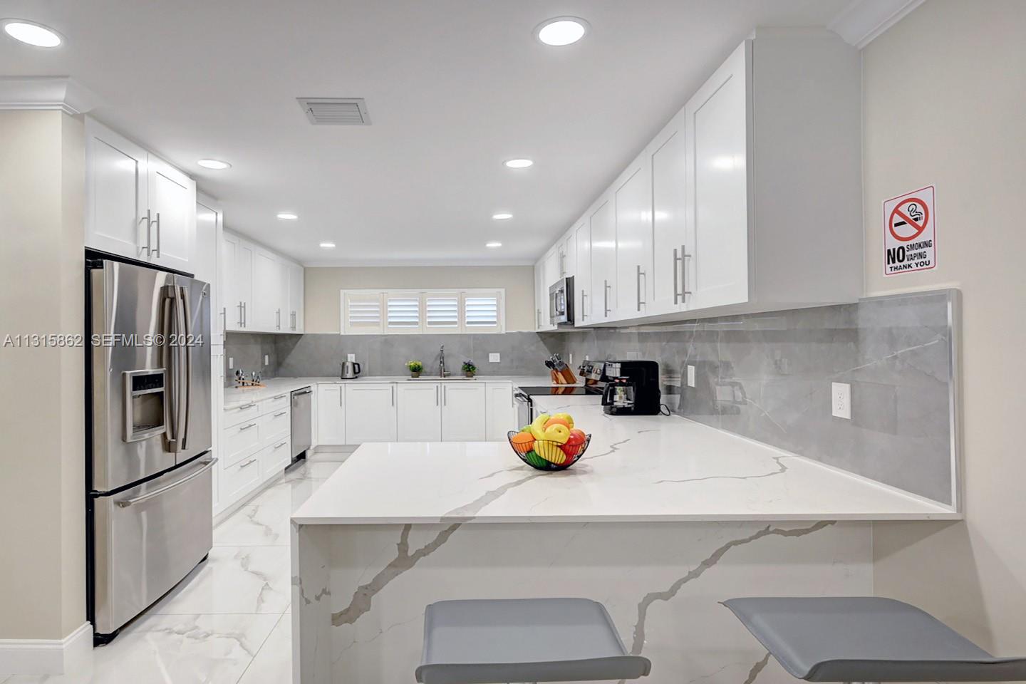 1307 Rodman Street Hollywood, FL 33019 - Photo 24 of 38 a kitchen with a sink a counter space stainless steel appliances and cabinets