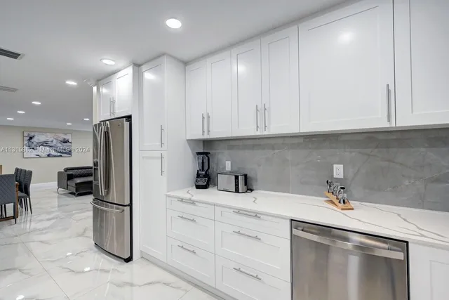 a kitchen with stainless steel appliances a refrigerator sink and cabinets
