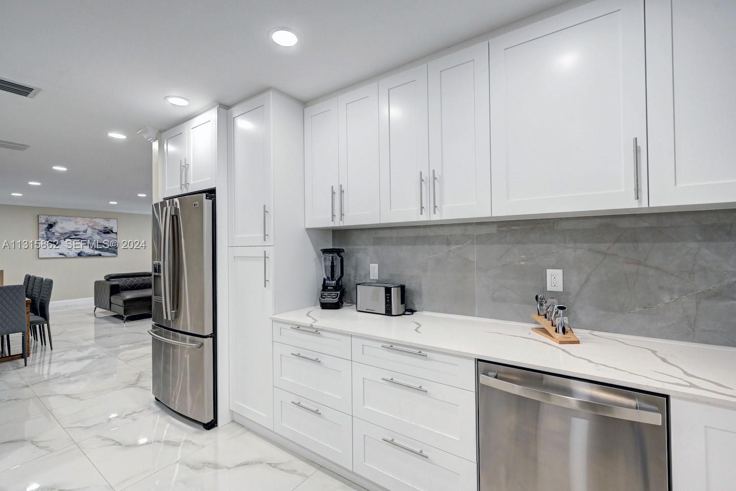 1307 Rodman Street Hollywood, FL 33019 - Photo 25 of 38 a kitchen with stainless steel appliances a refrigerator sink and cabinets