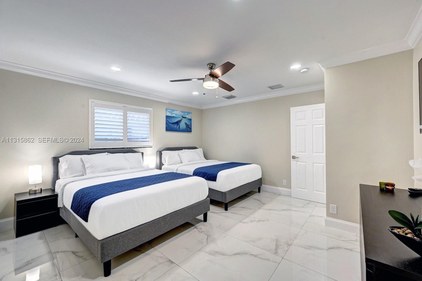 1307 Rodman Street Hollywood, FL 33019 - Photo 26 of 38 a spacious bedroom with a bed and a chandelier