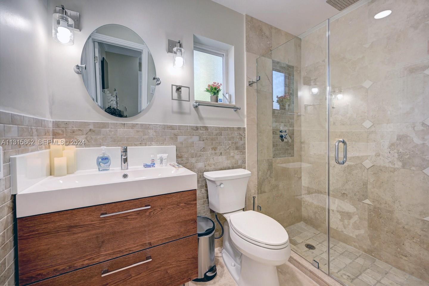 1307 Rodman Street Hollywood, FL 33019 - Photo 27 of 38 a bathroom with a toilet sink and mirror