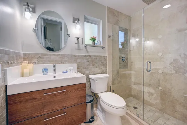 a bathroom with a toilet sink and mirror