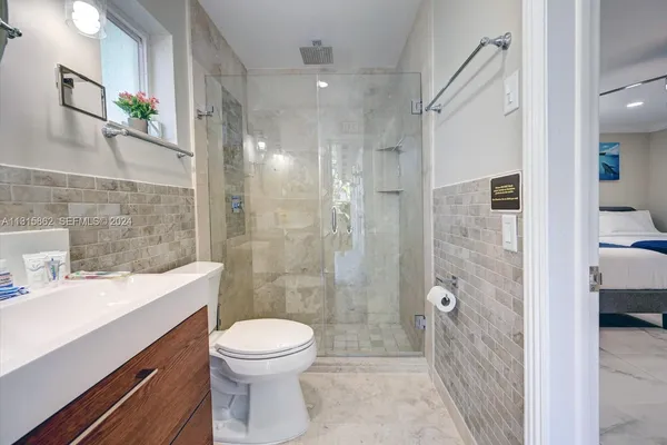a bathroom with a sink a toilet and shower
