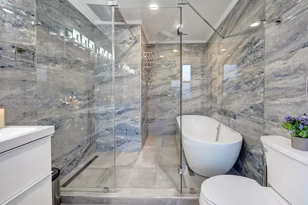 a bathroom with a sink a toilet a mirror a bathtub and shower