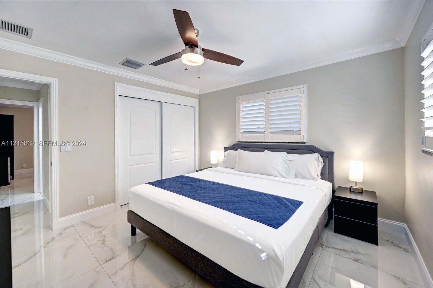 1307 Rodman Street Hollywood, FL 33019 - Photo 35 of 38 a bedroom with a bed and a ceiling fan