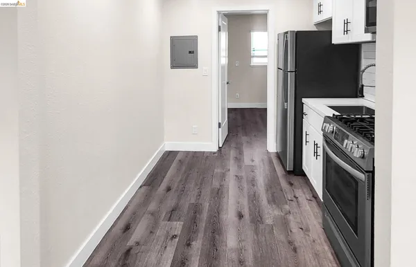 a kitchen with a refrigerator a stove and wooden floor