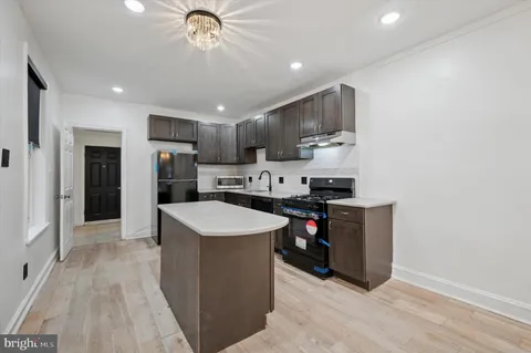 a kitchen with stainless steel appliances a stove a refrigerator a sink dishwasher and a oven with wooden floor