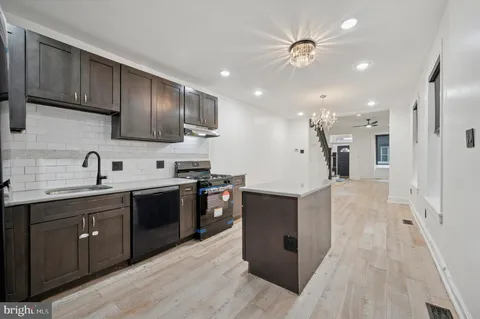 a large kitchen with stainless steel appliances lots of counter space and a sink