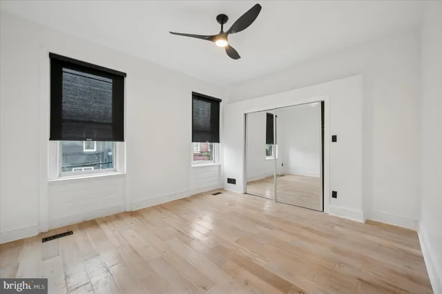 a view of an empty room with a window and a ceiling fan