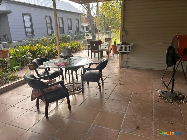 a view of a patio with table and chairs and potted plants