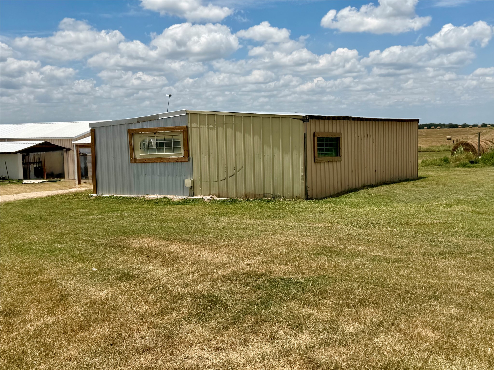 441 Molasses Road Dale, TX 78616 - Photo 29 of 36 Used to be horse barn. A utilitarian outbuilding with metal siding offers versatile storage possibilities on a spacious lot.