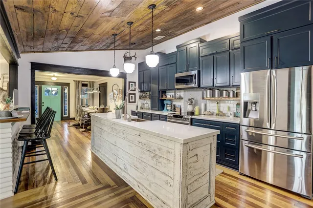 a kitchen with stainless steel appliances a stove refrigerator sink and cabinets