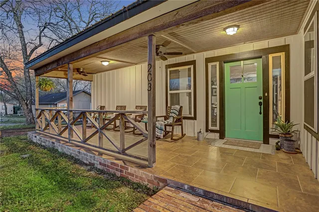 a view of a porch with furniture and a yard