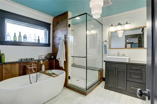a bathroom with a tub a sink and mirror