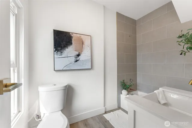 a white toilet sitting next to a bathroom sink and tub