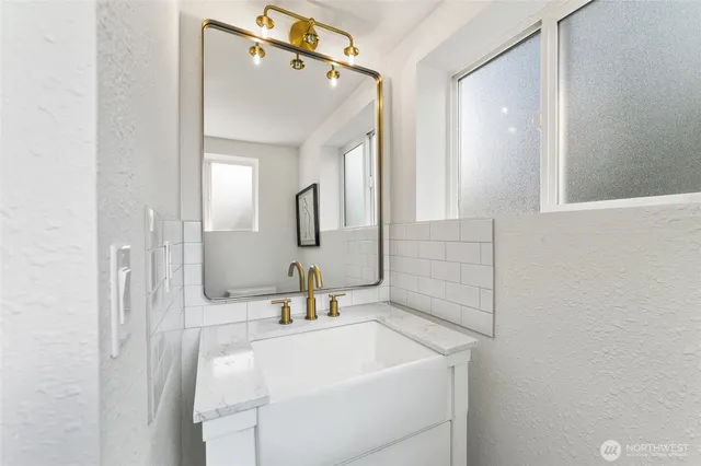 a bathroom with a sink a toilet and mirror