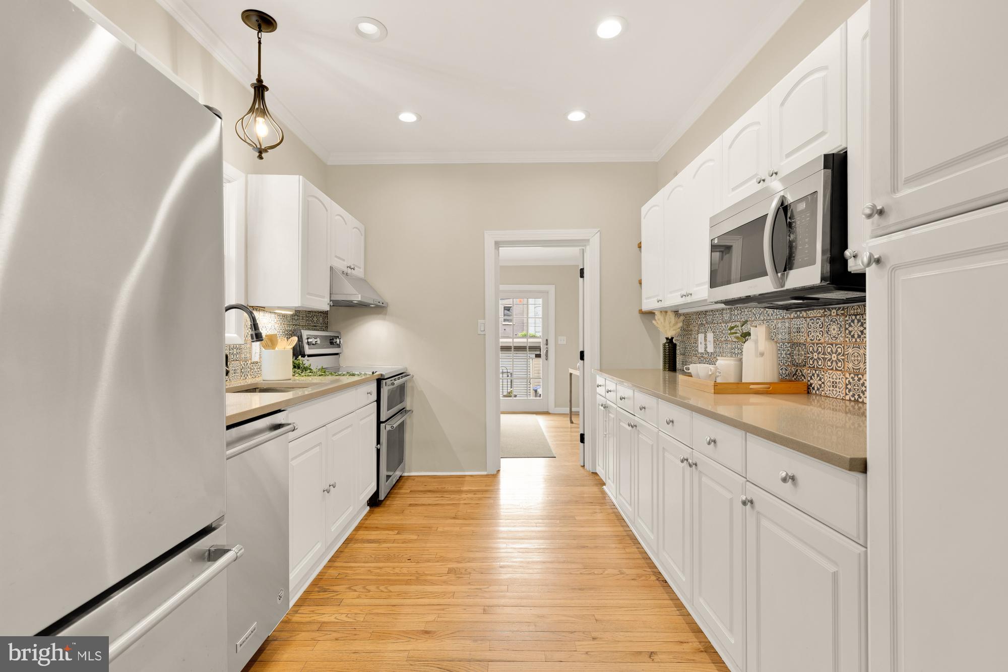 1112 Park Street Northeast Washington, DC 20002 - Photo 7 of 23 a large kitchen with stainless steel appliances kitchen island granite countertop a refrigerator a sink dishwasher a stove and white cabinets with wooden floor