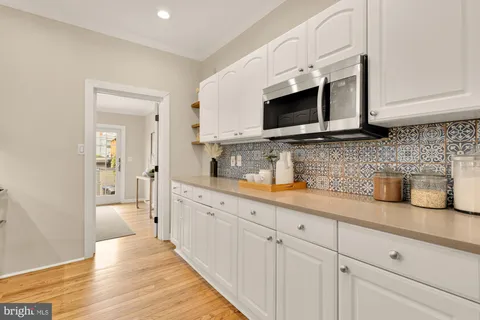 a kitchen with stainless steel appliances granite countertop white cabinets a microwave oven and a sink