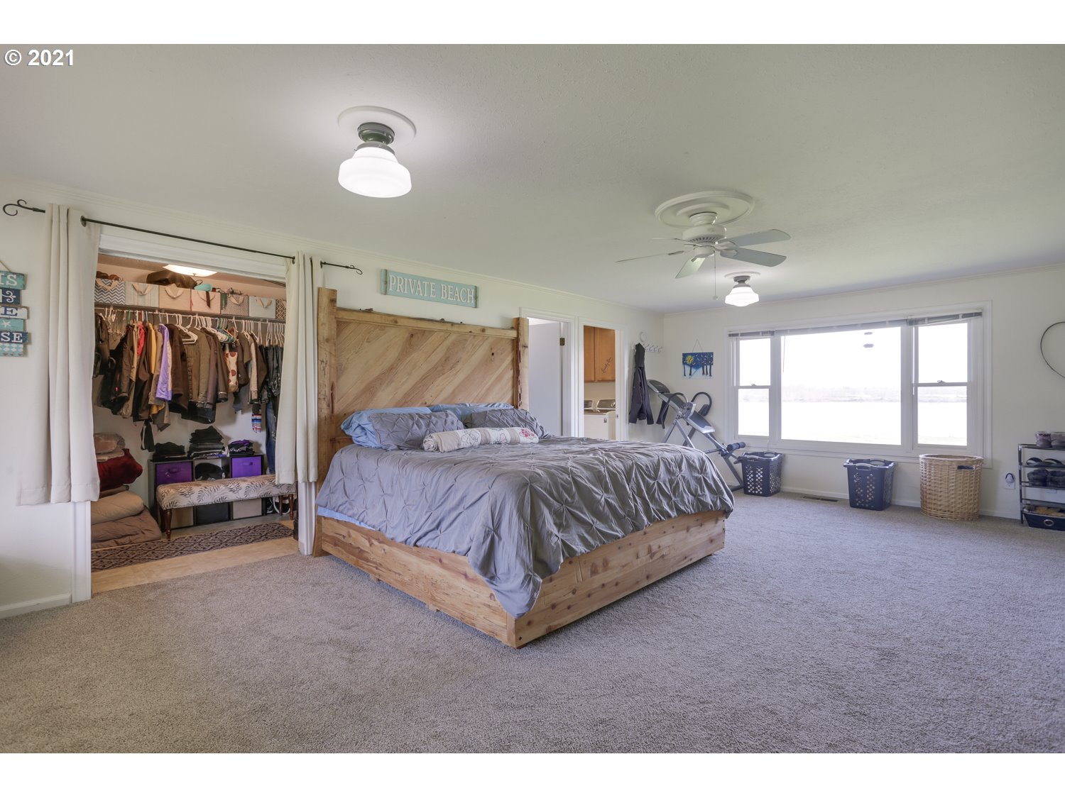 26440 Northwest Reeder Road Portland, OR 97231 - Photo 11 of 31 a spacious bedroom with a bed and a large window