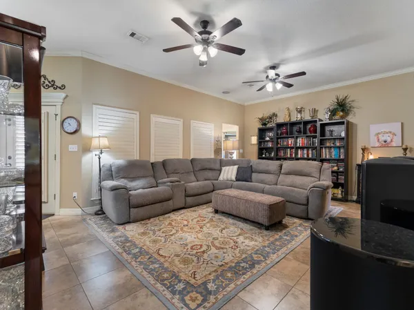 a living room with furniture a ceiling fan and a rug