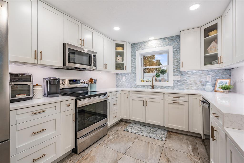 2020 Culberson Avenue Dunedin, FL 34698 - Photo 12 of 52 a kitchen with stainless steel appliances granite countertop white cabinets a sink and dishwasher