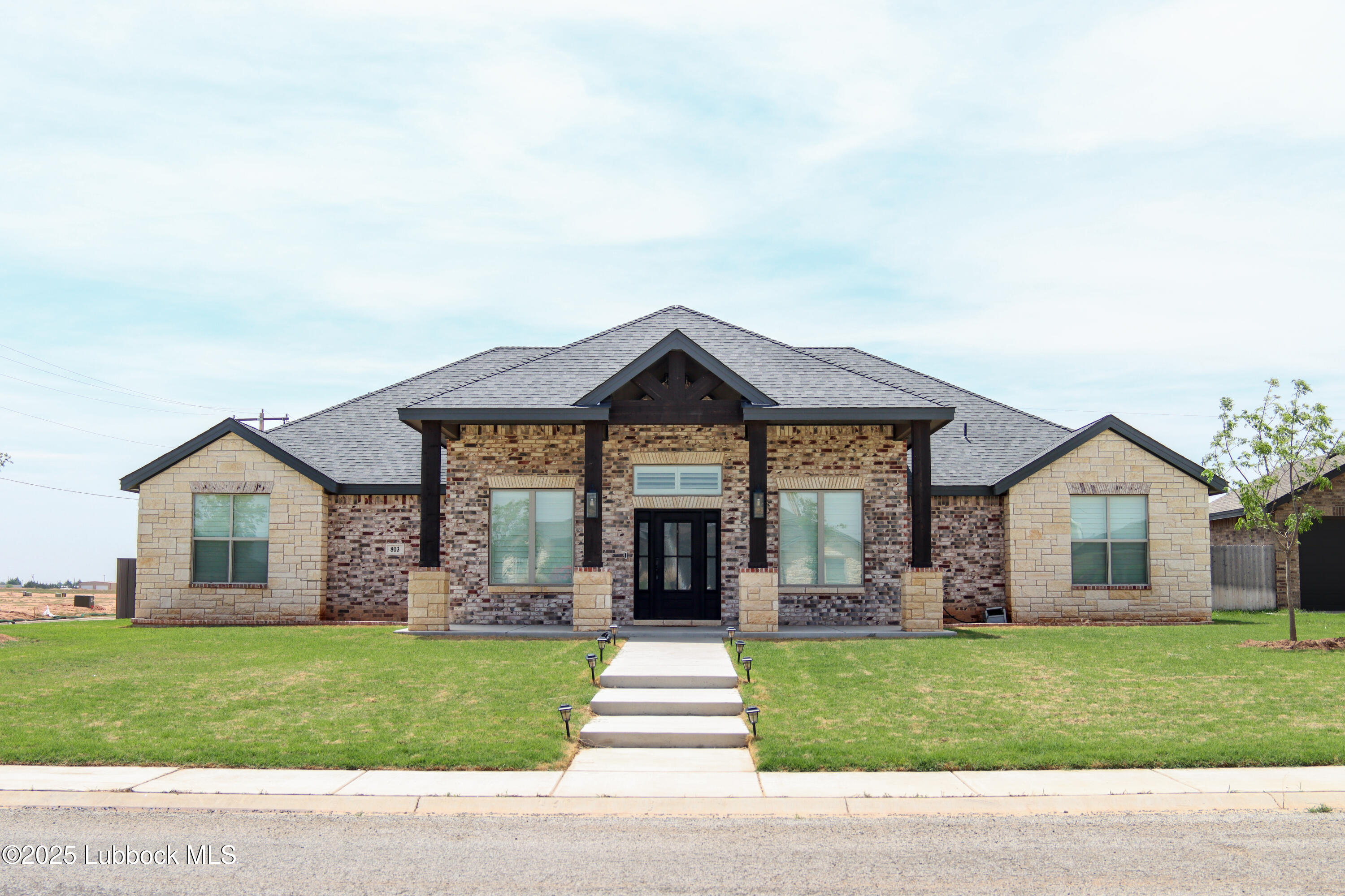 a front view of a house with a garden and yard
