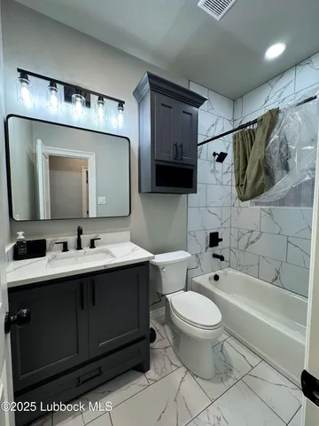 a bathroom with a toilet sink double vanity and mirror