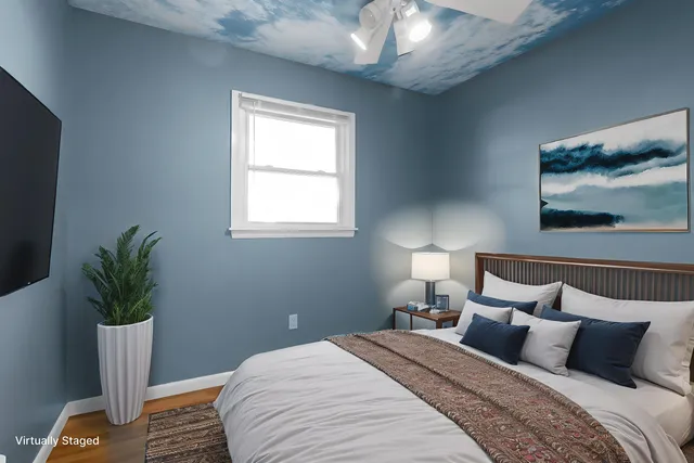 a bedroom with a bed and a potted plant