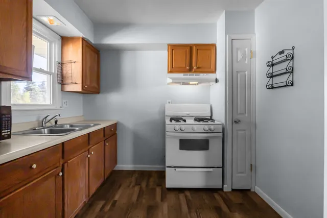 a kitchen with stainless steel appliances granite countertop a stove a sink and a refrigerator