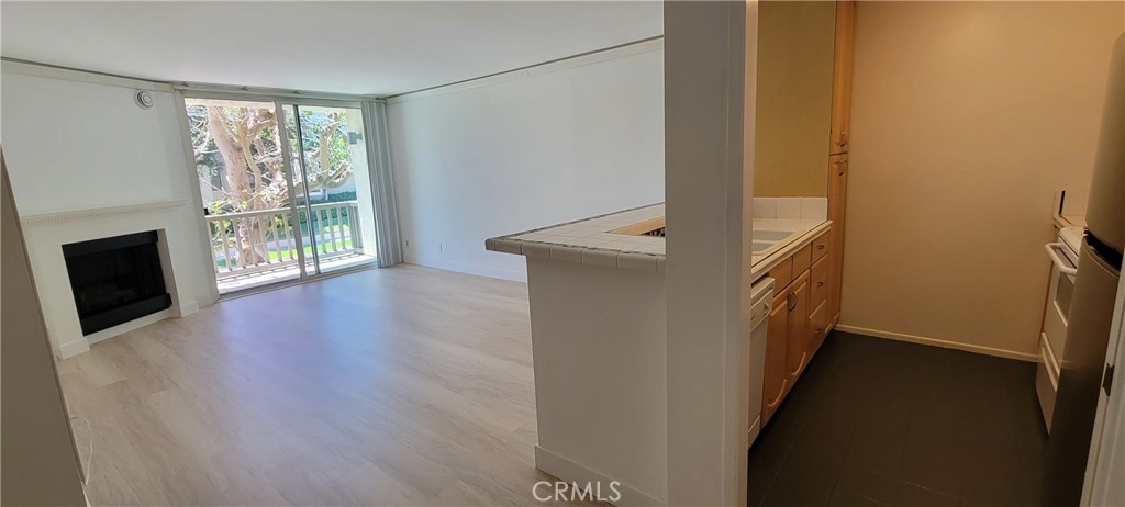 8740 Tuscany Avenue Playa del Rey, CA 90293 - Photo 6 of 21 a view of a hallway with wooden floor and a fireplace