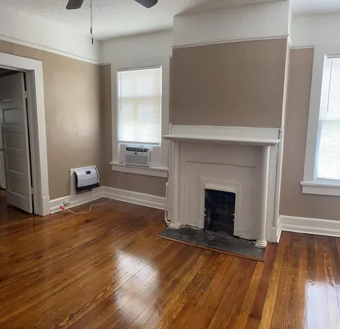 a view of empty room with wooden floor and fireplace