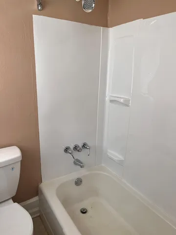 a white bath tub sitting next to a white toilet