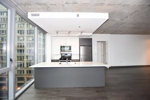 a view of kitchen with stainless steel appliances granite countertop a refrigerator and a stove