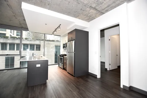 a kitchen with kitchen island a counter top space a sink and a refrigerator
