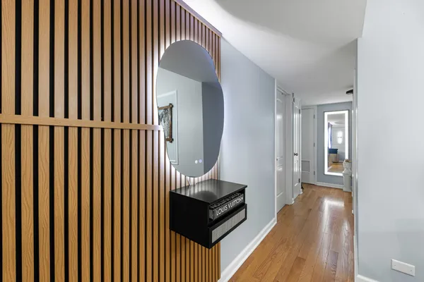 a view of a hallway with wooden floor and staircase