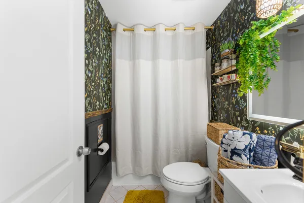 a bathroom with a toilet and a shower curtain