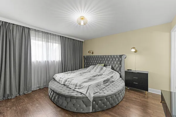 a bedroom with a bed and a chandelier