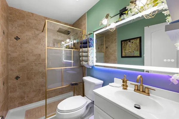 a bathroom with a sink vanity mirror and toilet