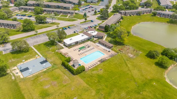 an aerial view of a swimming pool with outdoor seating