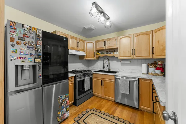 a kitchen with stainless steel appliances granite countertop a stove top oven a sink and dishwasher