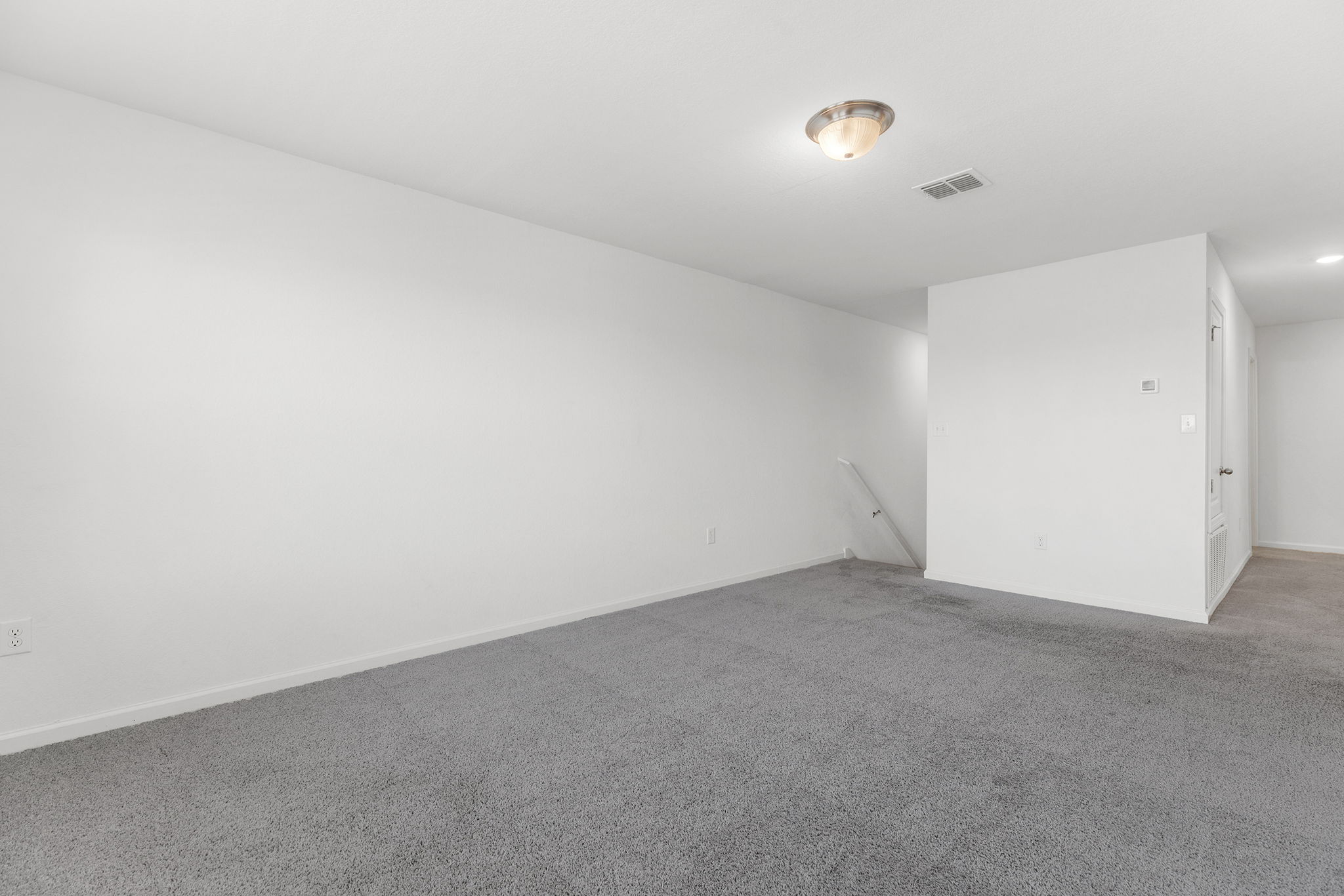409 Line Of Fire Way Jarrell, TX 76537 - Photo 16 of 30 Spacious room featuring neutral carpeting, white walls, baseboard trim, and open wall space for flexible furniture placement.