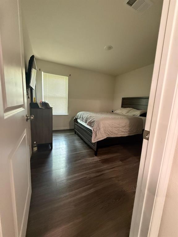 2614 Hooper Street Dallas, TX 75215 - Photo 9 of 13 a bedroom with a bed and wooden floor