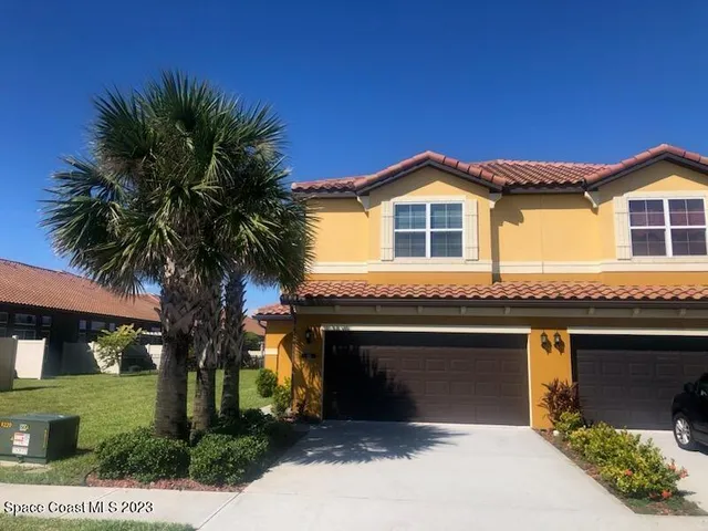 a front view of a house with a garden and yard