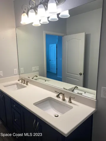 a bathroom with a sink a light fixture and a mirror