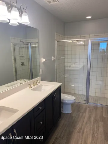 a bathroom with a double vanity sink toilet and shower