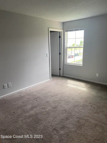 an empty room with windows and closet