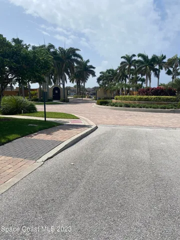 a view of a big house with a big yard and potted plants