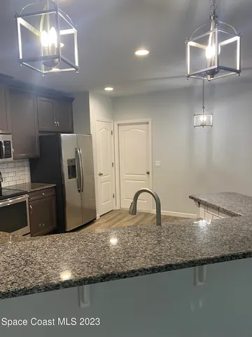 a kitchen with kitchen island granite countertop a sink cabinets and stainless steel appliances