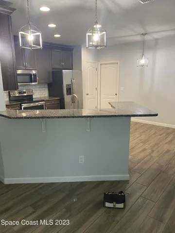 an open kitchen with granite countertop a stove and a sink